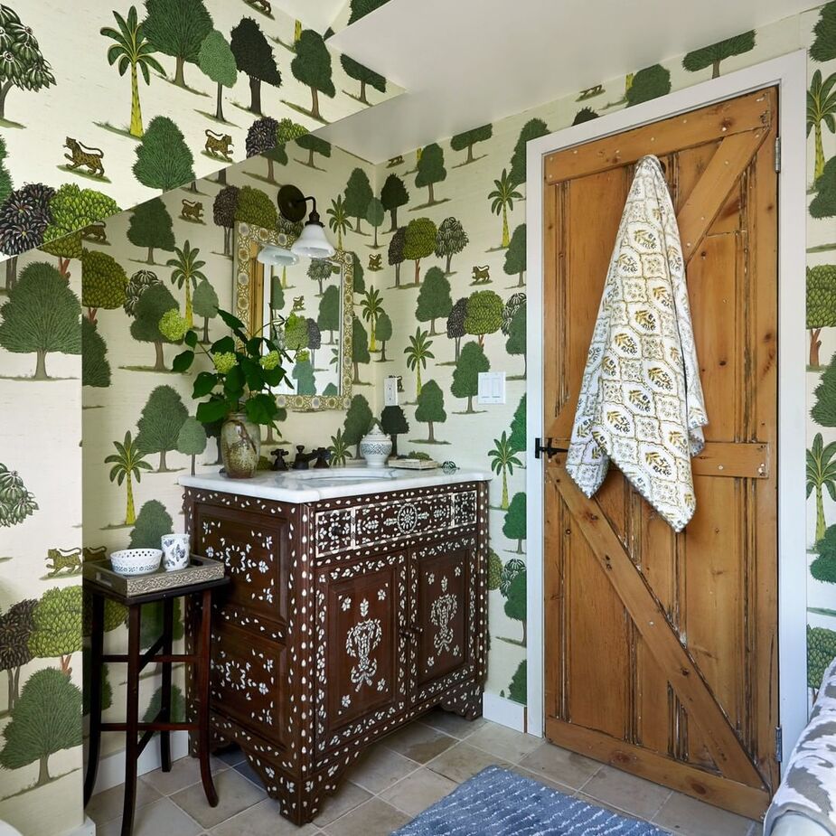 Another of John’s wallpapers, Kulina Moss, adorns the upstairs bathroom, along with a Syrian bone-inlay vanity.  
