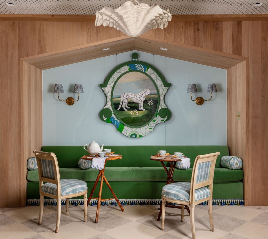 Sara Hillery transformed a hall into an homage to 18th-century tearooms. “I sought to design a space that intentionally promotes personal relationships over screen time,” she explains. French bed alcoves inspired the creation of the niche in which the green velvet sofa nestles. Art by Dana Gibson brings a dash of whimsy to the classic refinement. Find similar sconces here.
