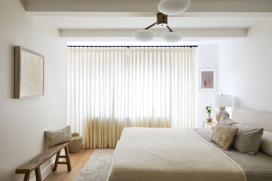 The primary bedroom’s quiet palette is a respite for a designer who works with color all day. Layers of texture, such as the weathered wood bench, the velvety rug, and the quilted coverlet, ensure plenty of visual interest, however.
