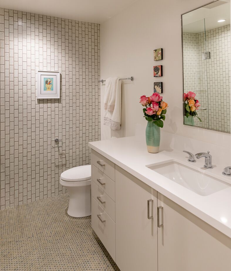 “When you are an interior designer, you have a responsibility to look after your client’s safety as well as make aesthetic choices,” Karen notes. “The small scale of the penny-round flooring reduces the risk of slippage due to the increased amount of grout creating more traction.” Vertical subway tiles on the walls contribute quiet contrast.
