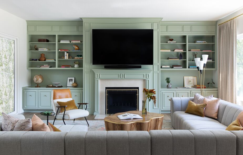 Previously the family room paired the traditional feel of the built-ins with a formal furniture arrangement that included a pair of sofas facing each other. Shannon opted to contrast them with more relaxed, modern furnishings and a fresh, light palette.
