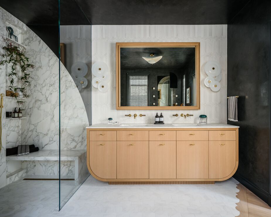 If any room could benefit from the introduction of a few sweeping curves, it’s the bathroom, which is usually dominated by hard surfaces and precise lines. Tineke Triggs made the primary bathroom conducive to relaxation with tiles in an arched motif, sconces made up of discs, and the rounded corners of the vanity. Photo by Christopher Stark.
