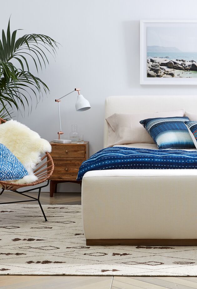 The sheepskin draped over the Acapulco chair can also adds softness and warmth underfoot or atop a bed. The footboard of the Leigh Linen Platform Bed is deep enough to serve as additional seating.
