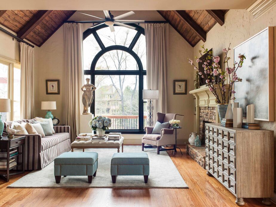 Pops of robin’s-egg blue—the ottomans, the table lamps, the pottery—enliven the keeping room’s neutral shades while referencing the beaded chandelier in the adjacent breakfast nook. Find a similar cocktail ottoman here; find a side table similar to the one beside the wingback chair here. 
