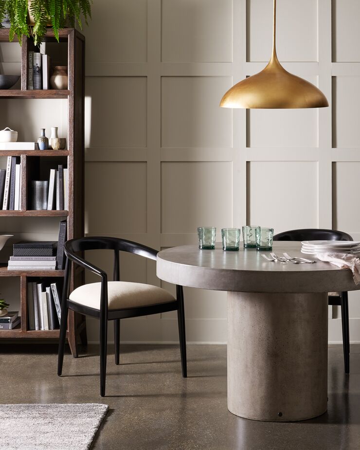 Comfort is paramount to quiet luxury, and with their ergonomic curves and lavishly cushioned seats, these dining chairs provide it. The golden Agnes Large Pendant warms up the concrete Circa Dining Table.
