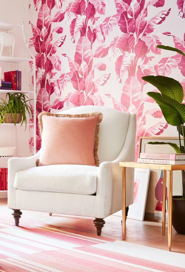 Pink palm fronds, courtesy of Electric Palm Wallpaper: What could be more Palm Beach than that? The paler pinks of the Arlin Flat-Weave Rug and the Celeste Velvet Pillow in Blush provide a tonal complement, with the Romy Performance Linen Chair in Snow giving the eye a place to rest. Photo by Joe Schmelzer.
