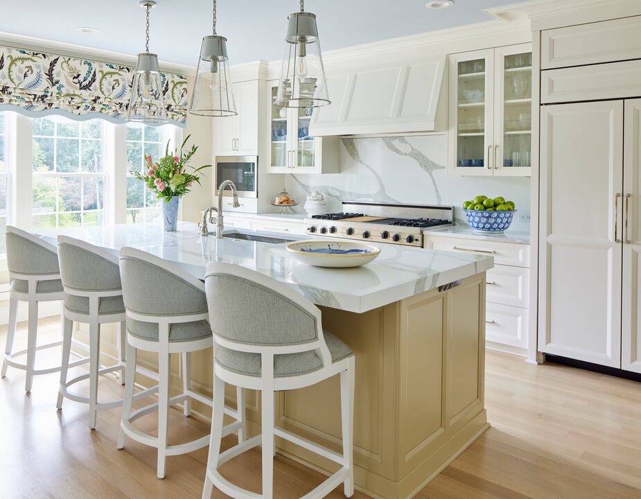 Amid the kitchen’s layered neutrals, the blue ceramics and the fanciful floral print of the window shades make an impact without disrupting the warm, welcoming vibe. Find similar pendants here. 

