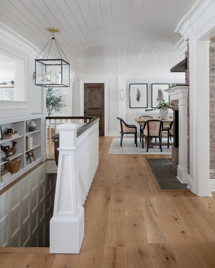 On the stairway leading to the basement, the square lantern echoes the millwork below the bookcase.
