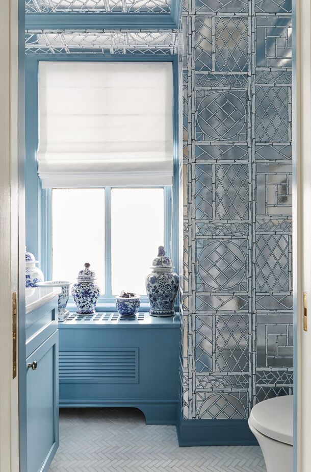 A custom design by Quadrille, the trellis on the Mylar wallpaper was painted with New Born’s Eyes—the same blue as the millwork—and Shaker Gray, both from Benjamin Moore.
