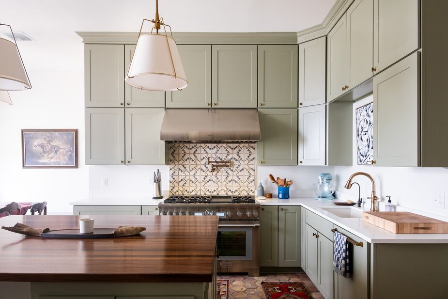 Vintage runners are layered atop the reclaimed terracotta floor tiles from France. The backsplash tiles are by Lauren Liess (you can find her furniture and art here). Art above the sink makes up for the lack of a view when washing up.
