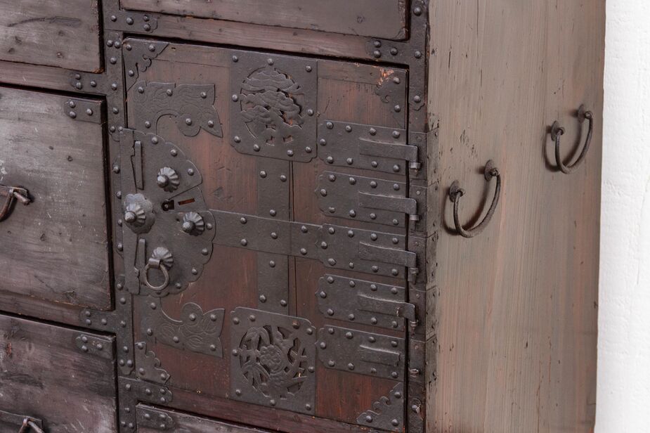 This antique tansu boasts elaborate hardware on this door, which opens to reveal a trio of drawers.
