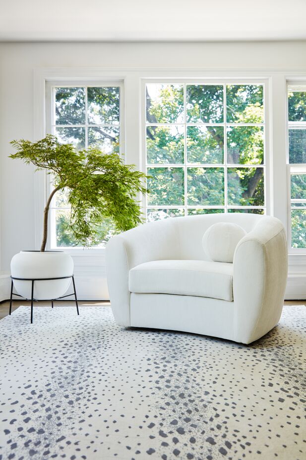 Simplicity at its most sophisticated and modern: the Colette Performance Linen Swivel Chair in Snow and the Fauna Rug in Bone. The chair’s stain-resistant, water-repellent upholstery, by the way, makes it practical as well as refined. Photo by Joe Schmelzer. 
