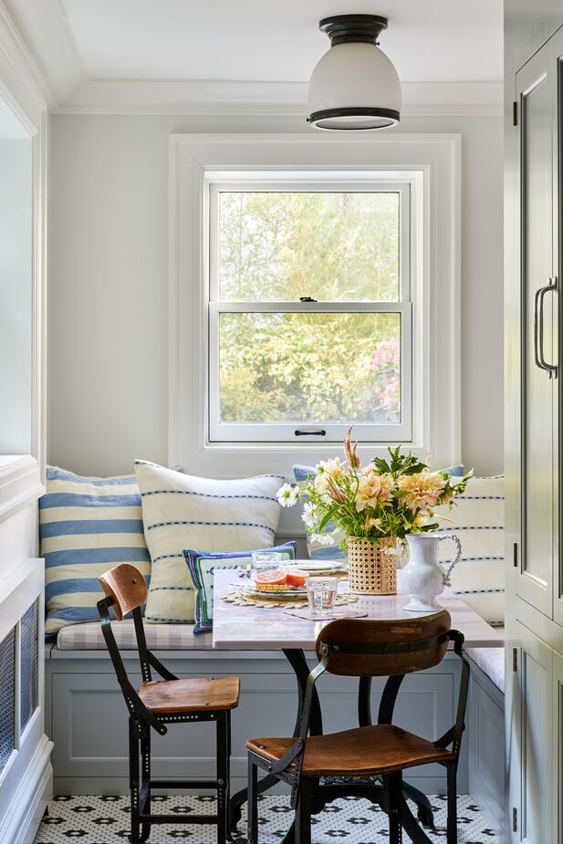 A breakfast nook was added to a sunny spot off the kitchen. The built-in banquette and the vintage chairs bring functionality as well as charm. 
