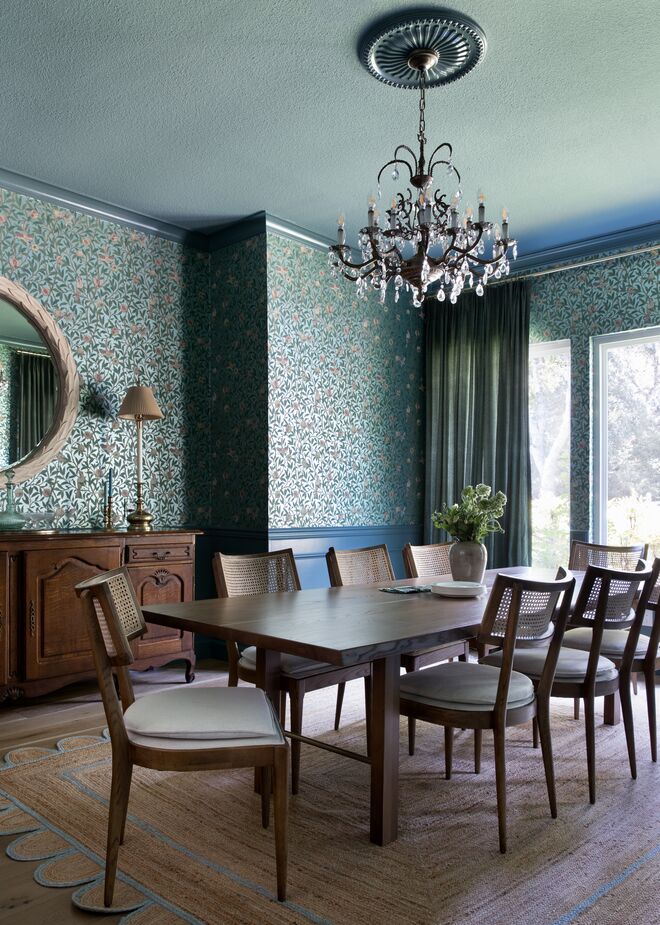 Shannon played up traditional elegance in the dining room with formal moldings, botanical wallpaper, and a crystal-embellished chandelier. The peacock-blue paint, the streamlined chairs and table, and the whimsical natural-fiber rug provide a contemporary balance.
