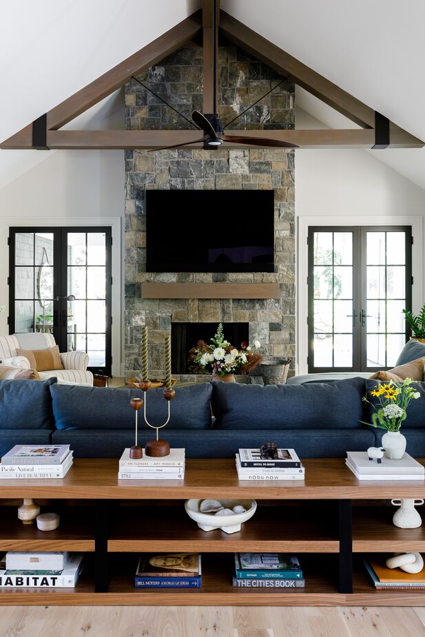 Black accents and hits of blue balance out the family room’s paler woods and walls.
