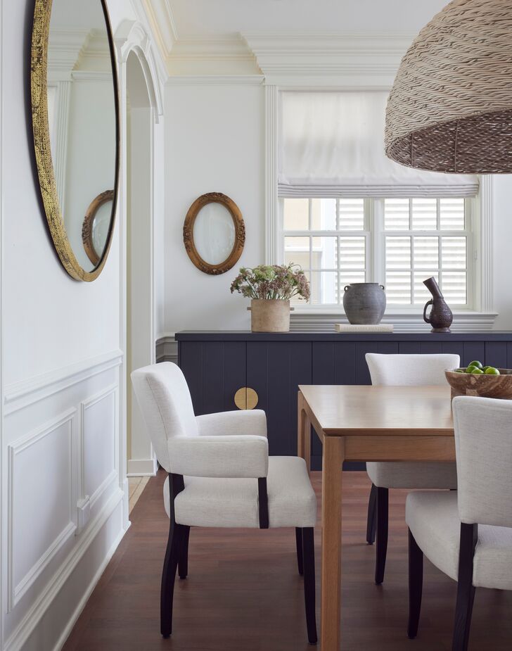 A custom black buffet cabinet in the dining room serves as both storage and a fashionable serving station for parties.
