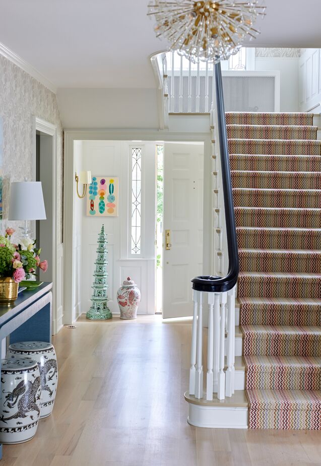The entryway offers a preview of the rest of the home: classic silhouettes and sunny colors. Find a similar chandelier here. 
