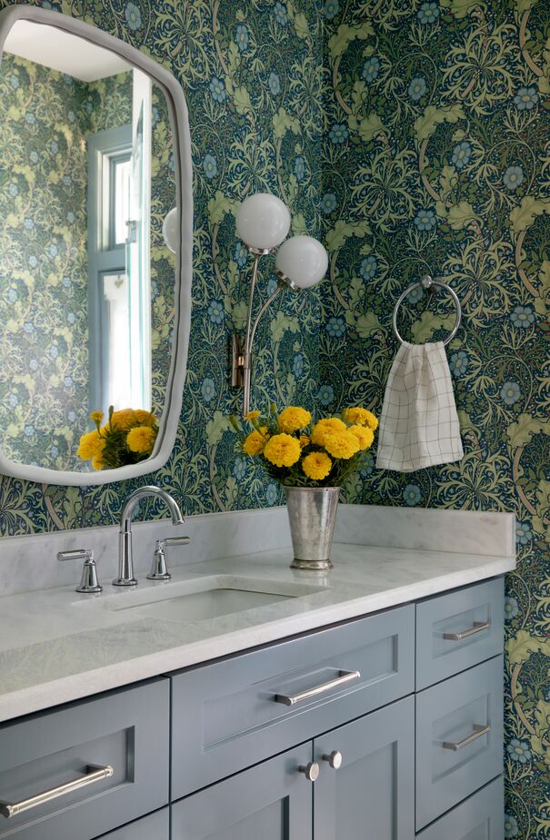 Juxtaposed against the traditional wallpaper, the contemporary sconce (find similar here) and mirror help “keep things unexpected,” according to Shannon.

