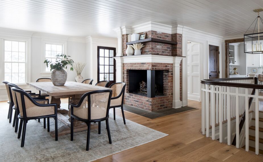 The understated furnishings make sure that the dining area’s fireplace commands attention. Find similar chairs here and a similar dining table here. 
