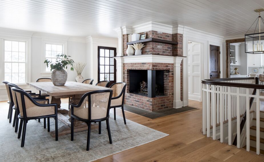 Easy does it for the dining area in the New Jersey home of Trish Lynn, founder and principal designer of Colette Interiors. The neutral tones of the bentwood chairs and the trestle table allow the fireplace, the wood-planked ceiling, and other architectural elements to command attention. See more of her home here. Photo by Raquel Langworthy.
