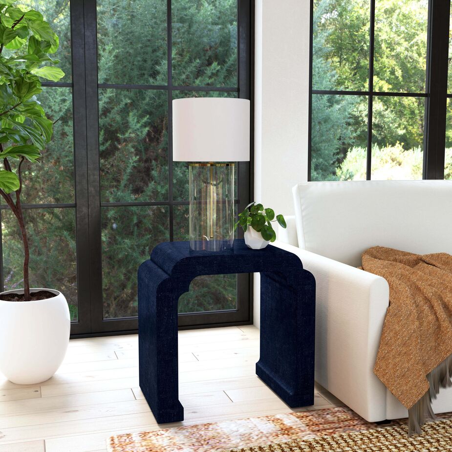 With its waterfall curves, the Kos Raffia Side Table is a subtle way to complement a surfeit of angles. The same goes for the oval planter and the cylindrical lamp.  
