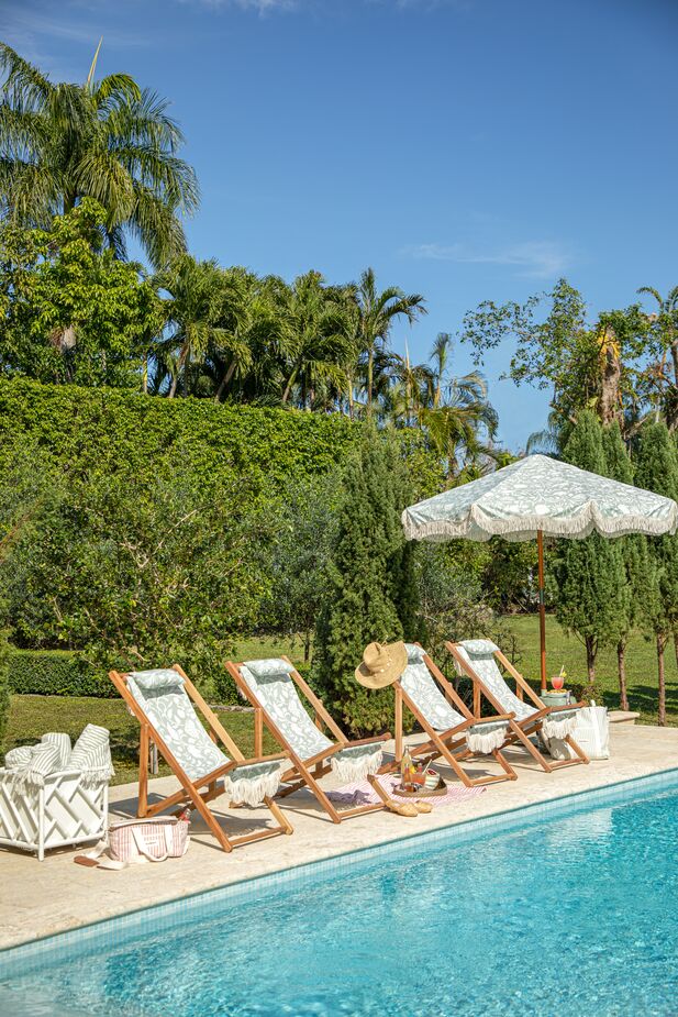 Shown above: the Kit Chippendale Large Planter in White, Flora Sling Chairs, and the Flora Patio Umbrella. Photo by Matt Albiani.
