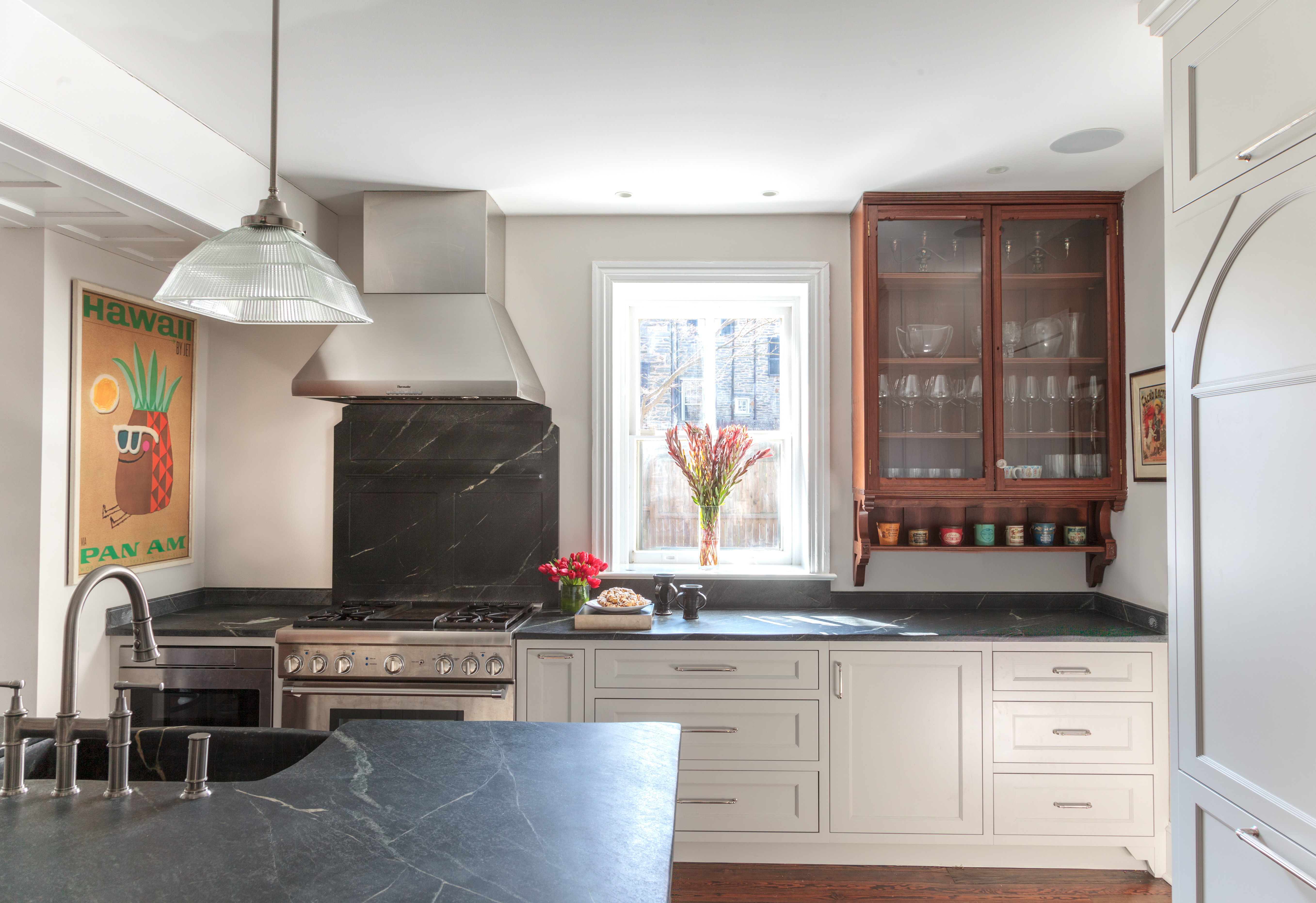 “This look started with an idea about restoring and emphasizing some of the historic elements of the original 1863 house while creating a more modern, functional, and beautiful kitchen,” says Mindy O’Connor of Melinda Kelson O’Connor Architecture & Interiors. “Start with one or two dominating features. Here, the refinished American walnut-and-glass cabinet and the soapstone countertops and sink are the stars.” While the cabinets are finished in a neutral hue, it’s one that’s softer and less in-your-face than white would be here. “Mixing natural materials like wood and dark stone complements almost any color choice,” Mindy notes, “and adds warm and natural touches to the space.” Photo by Wendy Concannon Photography.
