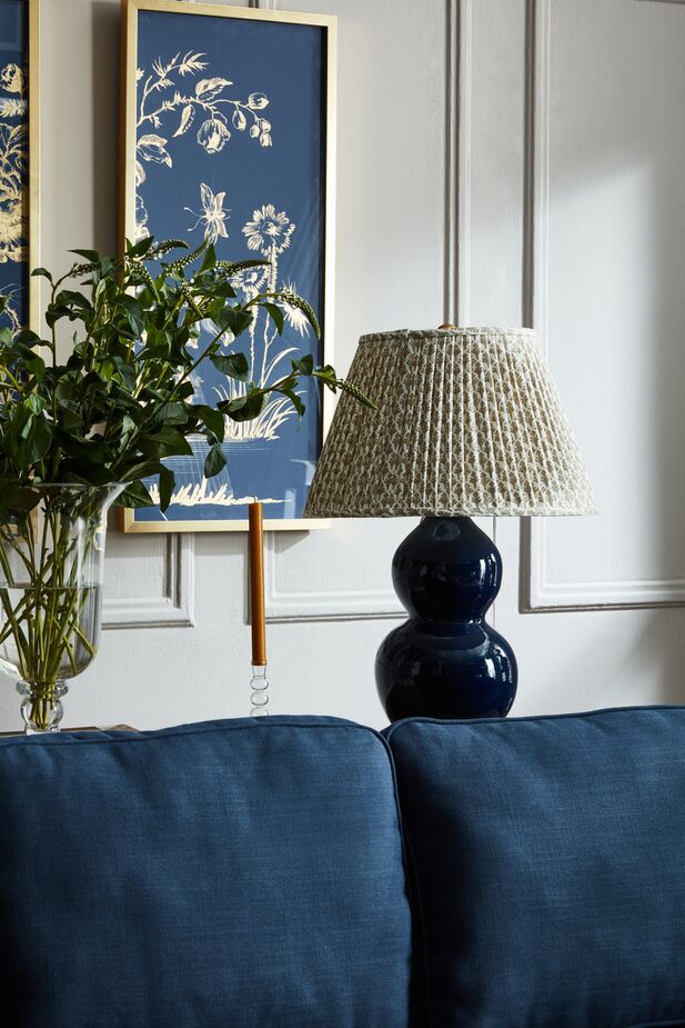 Side tables aren’t the only places for table lamps in a living room. Try positioning one on a console behind a sofa for use as a reading lamp. Find a similar lamp here and a similar lampshade here. Photo by Frank Frances.
