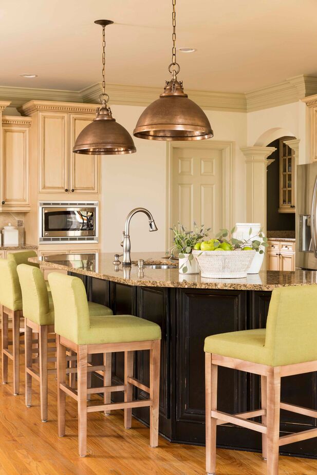 The stools’ low backs make it easy for anyone working in the kitchen to see and chat with guests in the keeping room. Find similar pendant lights here. 
