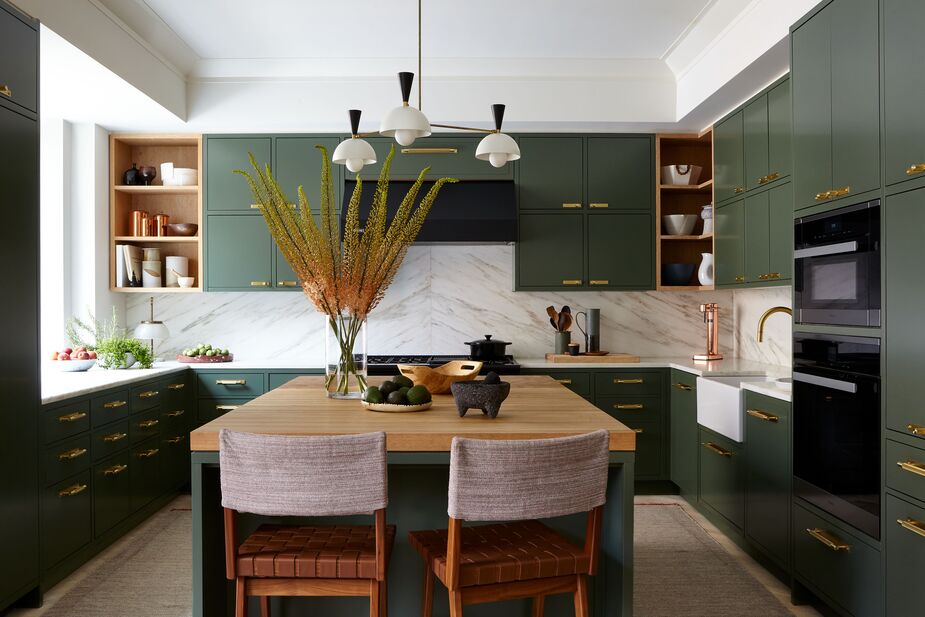 The stools’ woven leather seats and fabric backs accentuate the warmth of the kitchen’s jewelry-like hardware and richly figured oak island countertop.
