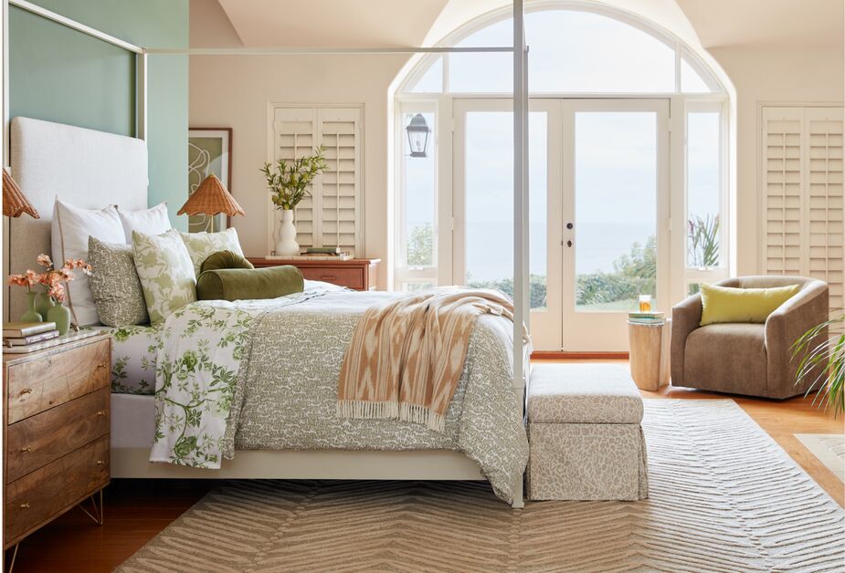 Above: Amalfi Canopy Bed in White; Parasol Rattan Table Lamps; Josephine Sheet Set in Sage; Fern Duvet Cover in Olive; Hayworth Pounce Storage Bench in Taupe; Carver Performance Velvet Swivel Chair in Camel. 
