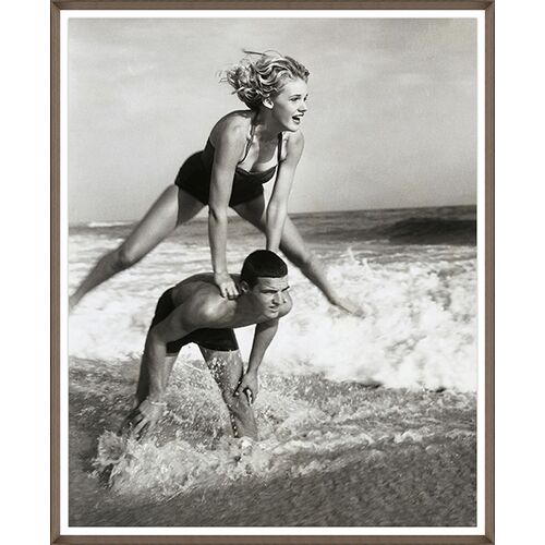 Young Couple Playing Leapfrog in Surf Framed Photograph Young Couple Playing Leapfrog in Surf Framed Photograph