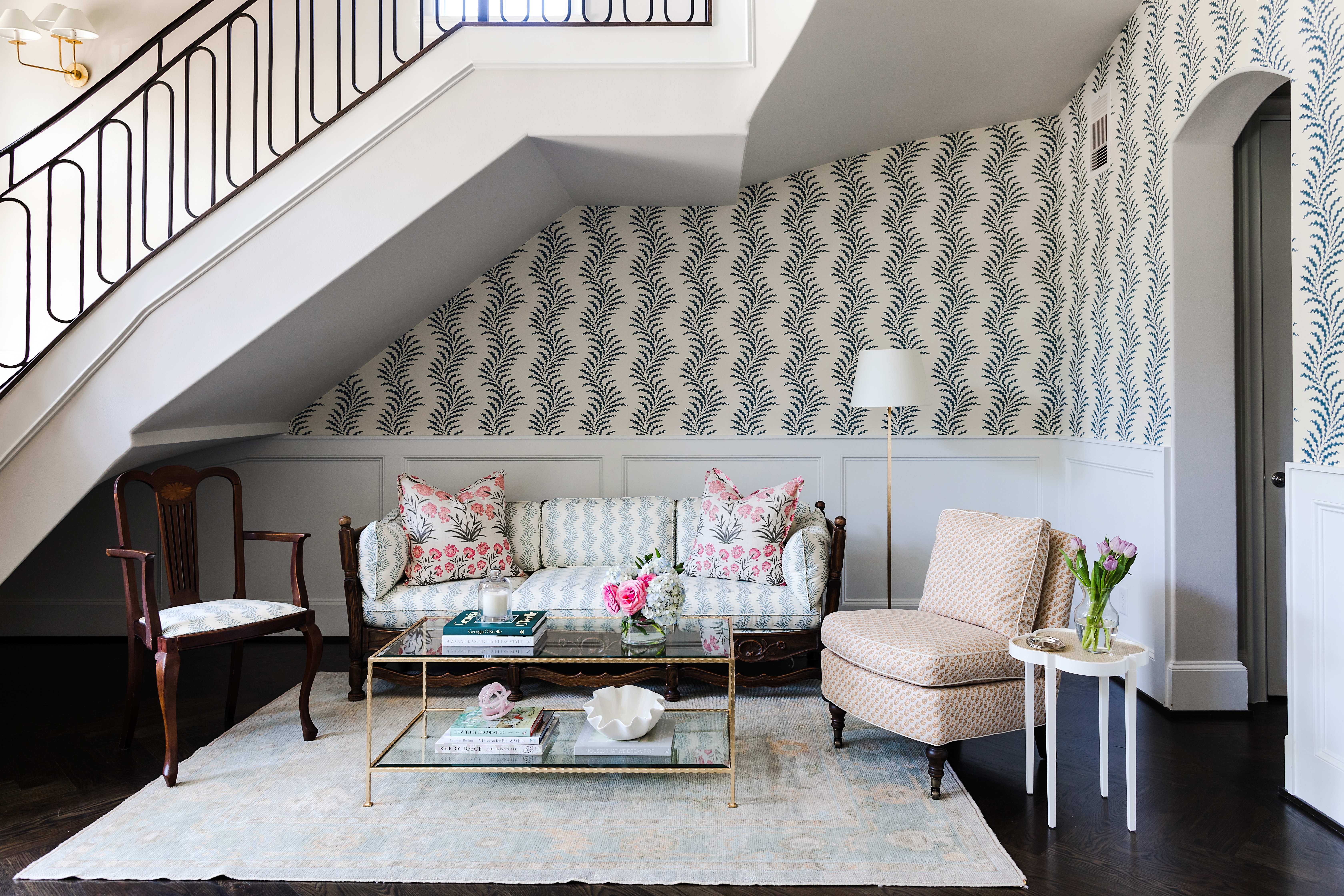 Designer Katie Davis transformed this awkward space under a stairway into a sitting area in part by spotlighting it with wallpaper. Photo by Melissa Fitzgerald West.
 
