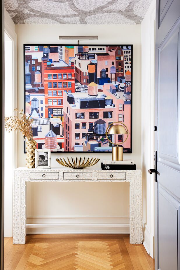 It’s counterintuitive but true: An oversize artwork can make a small space look larger than several smaller pieces would. Case in point: this foyer designed by Nikki Chu for actress Nicole Ari Parker featuring NYC Water Tanks by Toni Silber-Delerive. Find the console here. Photo by Erin Kunkel.
