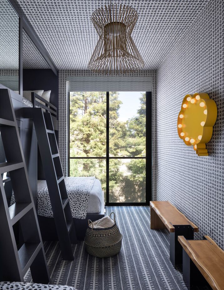 “I’d never designed a bunk room before,” says Benjamin, who is justifiably proud of this one. The layers of pattern more than make up for the monochromatic palette, which is broken only by the wall art and benches.
