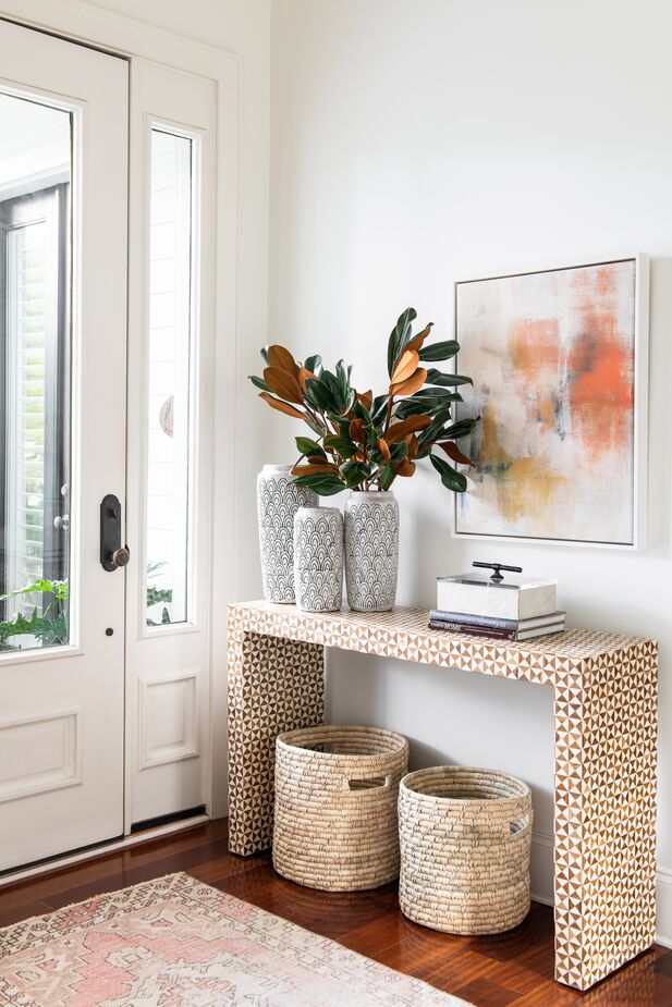 Baskets beneath the console provide unobtrusive, stylish storage. Find the rug—a durable wool/nylon blend—here. Room by One Kings Lane Interior Design; photo by Katie Charlotte Lybrand.
