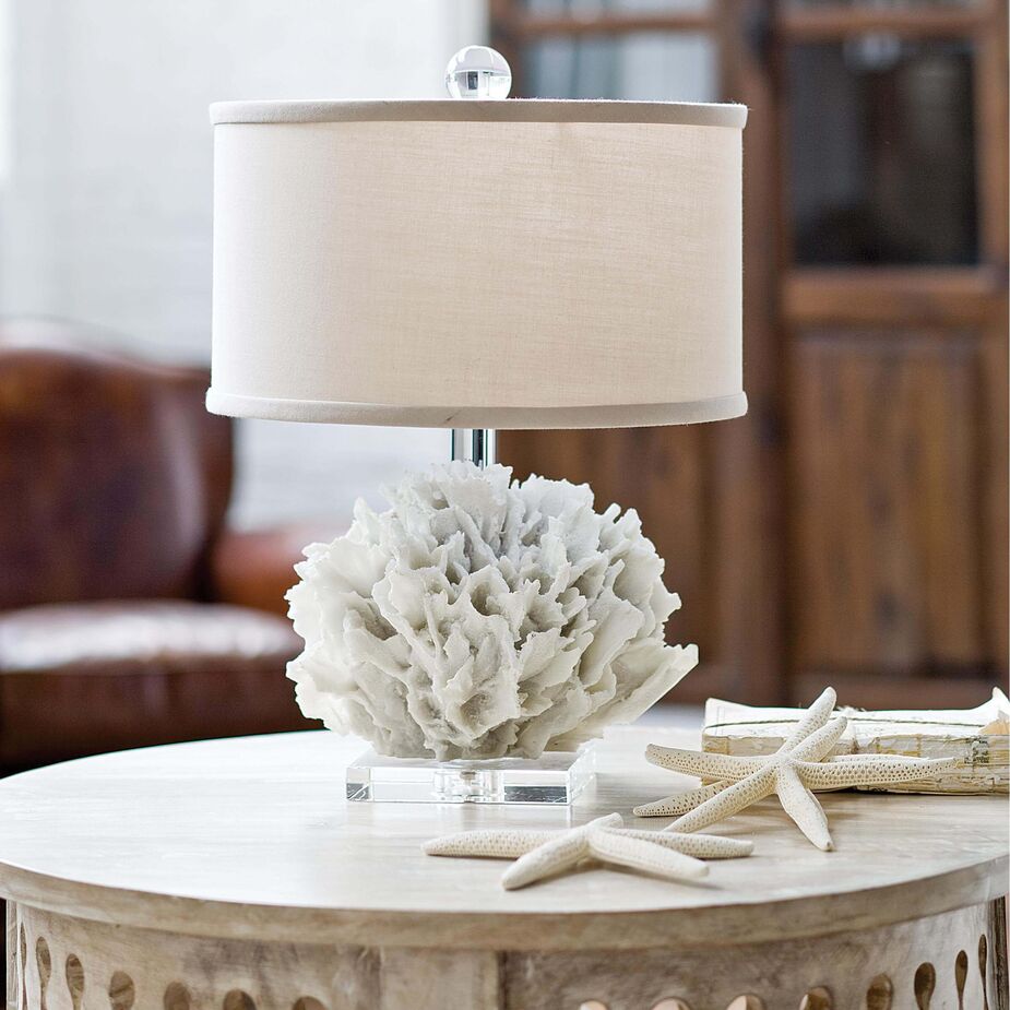 Left: The Old World look and feel of the cast resin Lucia Table serves as a stately balance to the cantilevered curves and casual-cool weave of the Paulina Chairs. Photo by Frank Frances. 
Above: Plaster and resin can replicate natural elements such as coral to an uncanny degree. The Ribbon Coral Lamp is one example.
