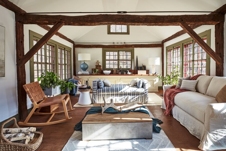 The Mid-Century Modern rocking chair and the mod side table breathe new life into this modern farmhouse room. Find a similar slipcovered sofa here. Photo by Frank Frances.
