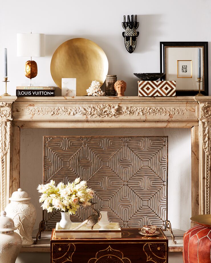 Organic elements such as a piece of coral and a teak-and-bone box sit alongside glamorous accents such as the golden charge. The resulting scene is rich with layers and intrigue.  
