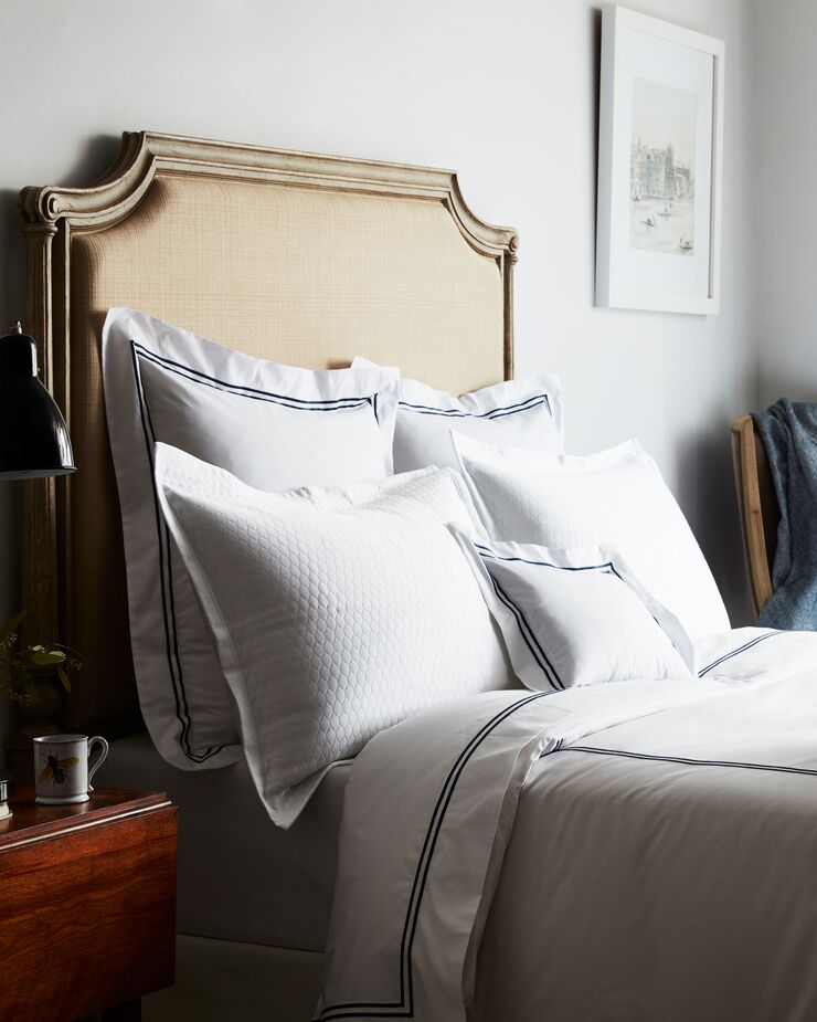 Even those who prefer bolder styles can appreciate quiet luxury in the bedroom. Here, bedding from Sferra’s Grande Hotel collection, woven in Italy of long-staple cotton, offers tactile opulence. The white cotton matelassé Favo Shams are equally sumptuous. Photo by Frank Frances.
