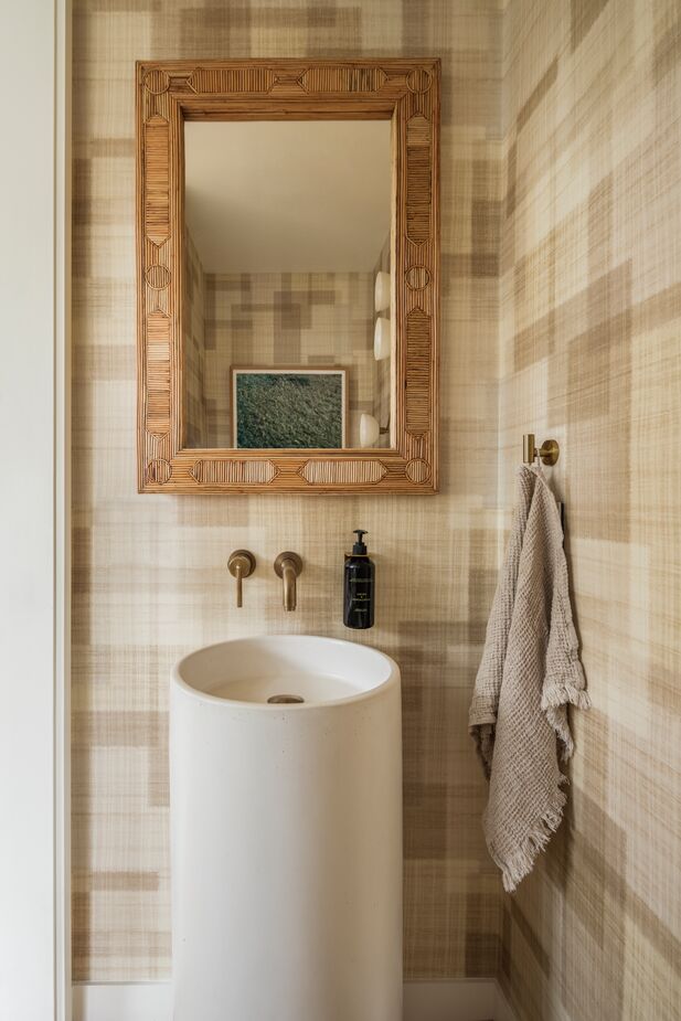 Neutral patterns and a mix of contemporary and organic materials feature in the guest bathroom. 
