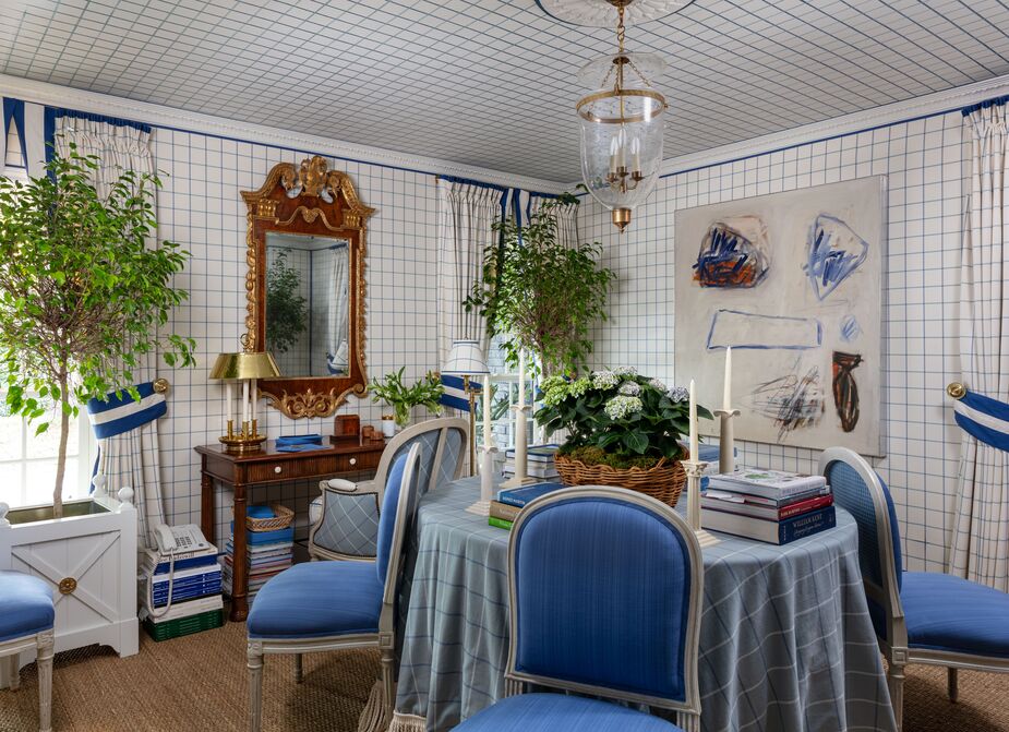 Mark D. Sikes named this dining room/library/office Villa Windowpane, and it’s easy to see why. The easy elegance of Billy Baldwin and Hubert de Givenchy provided inspiration. The dark wood desk, the gilded mirror, and the natural-fiber rug bring just enough contrast to the predominantly blue-and-white palette. Find a similar pendant here.
