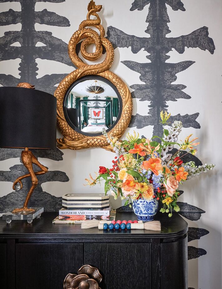 With this bedroom vignette, Veronica Solomon of Casa Vilora Interiors shows that disparate items can indeed work together to make a beautifully cohesive whole. It helps to stick to a curated palette—here, black and gold are the principal shades, and the pink and red of the calligraphy brush handles are repeated in the floral arrangement. Find the demilune cabinet here.
