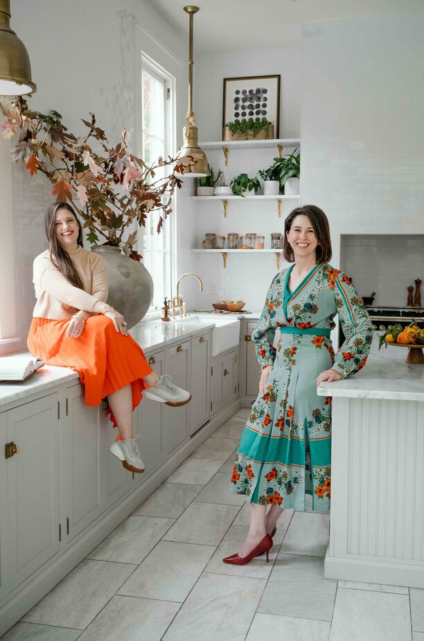 Homeowner Ellen Archer and designer Bethany Adams in the home’s kitchen. “Putting the pendants in front of the windows rather than over the island is a feature I’m particularly proud of,” Bethany says. “It’s different, but still looks classic.” 
