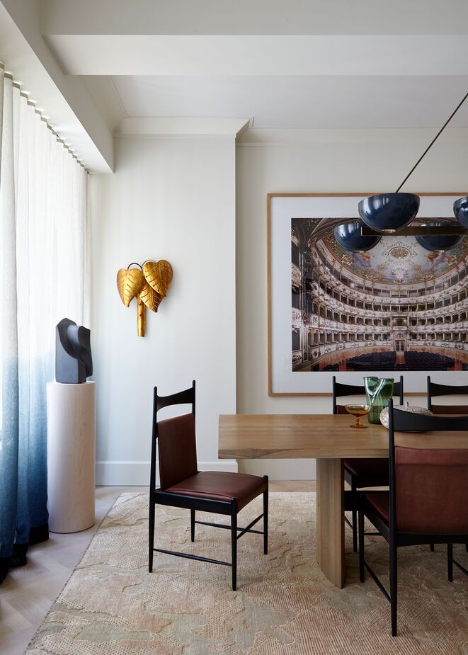 The gossamer curtains and the high-low texture of the blush-pink rug balance the straight lines and bold materials of the dining table and chairs. 
