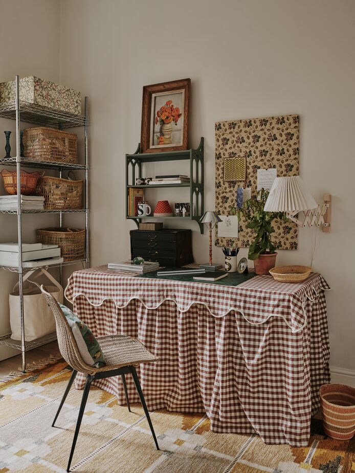 Sally uses the flat’s second bedroom as her office. While the metal storage unit is industrial in style, the addition of woven baskets and fabric-covered boxes enables it to fit right in with the room’s cottage style.
