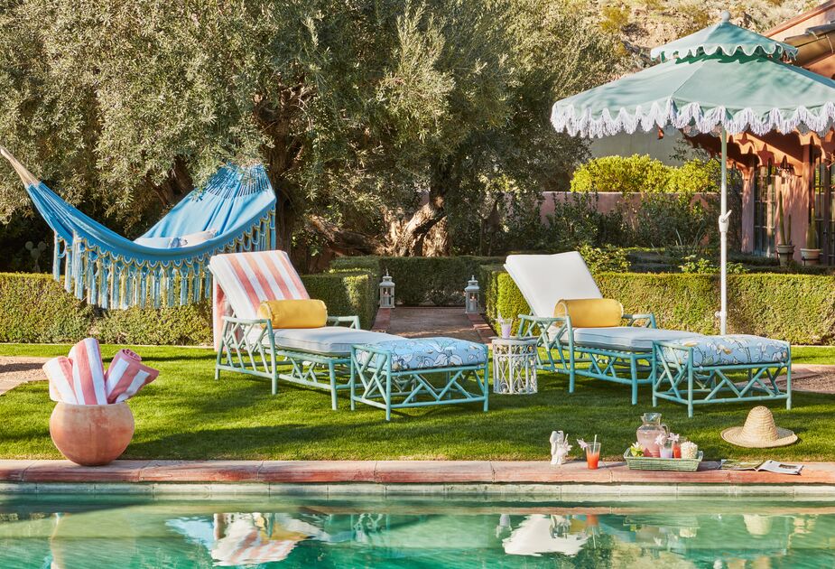 Who needs to jet away for a vacation when you can laze on a Kit Chaise in your own backyard? Also shown: Kit Ottomans and the Hannah Two-Tier Patio Umbrella in Mint/White.
