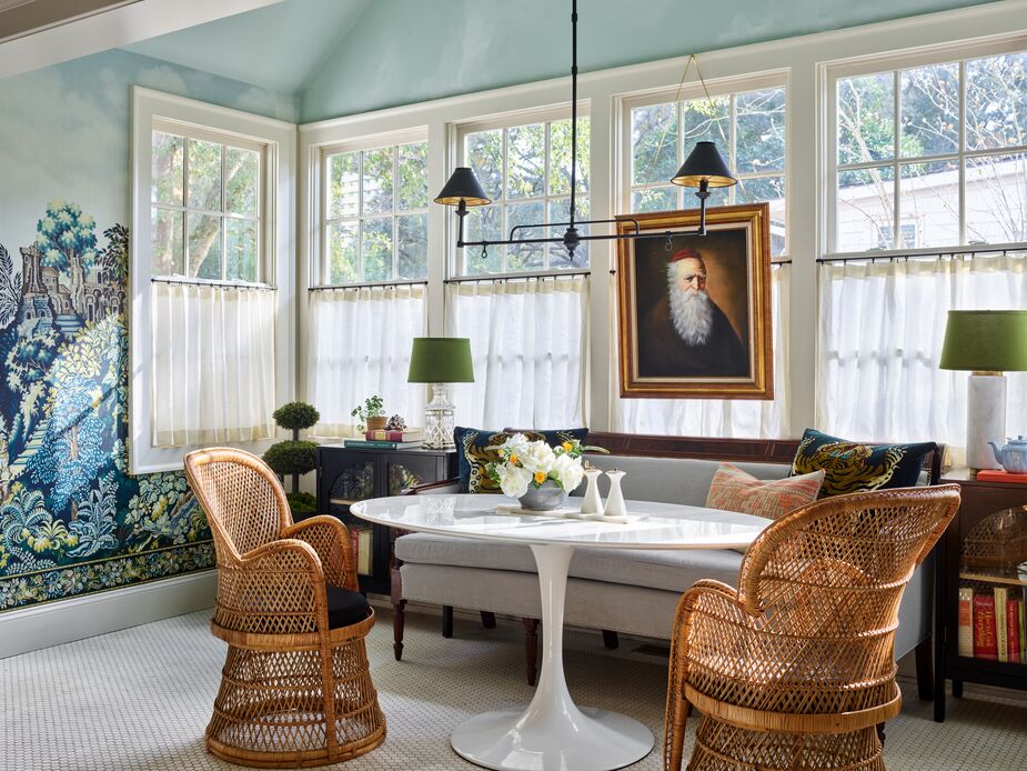 The Tulip-style table brings Mid-Century Modern gloss to the breakfast room’s more-traditional elements. Though the table lamps don’t match, their green shades lend a sense of cohesiveness. 

