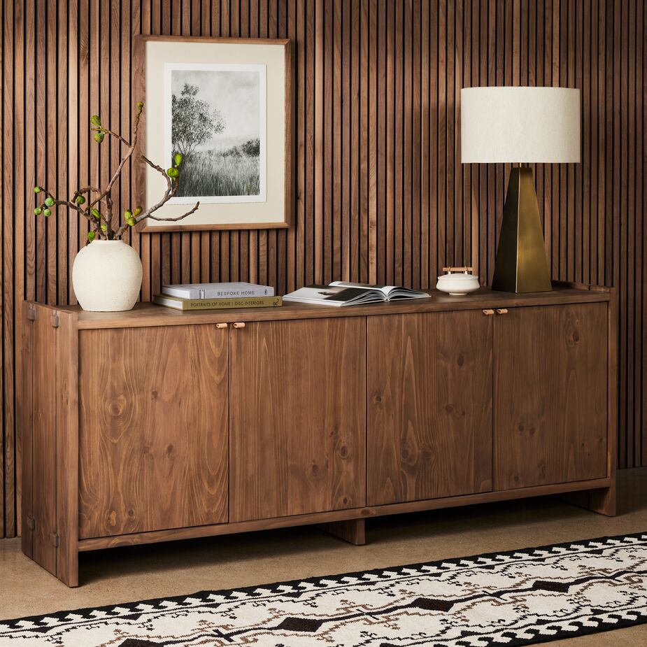 Layers of brown can create a cocooning effect. Try to vary tones, textures, or both, though. Here, the sinuous grain of the sideboard offers a contrast to the vertical reeding of the wall (which is a fresh take on traditional paneling).
