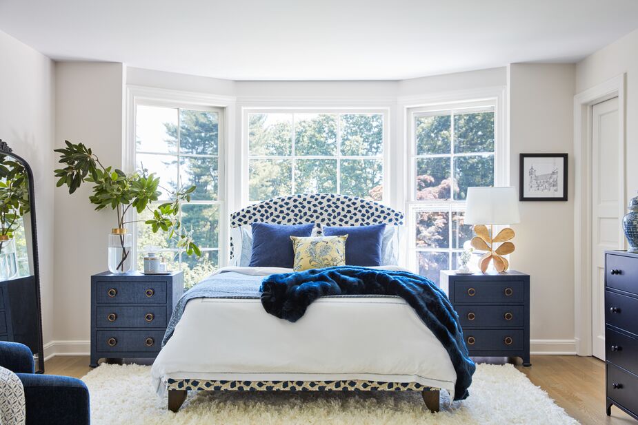 The blue-and-white palette is undeniably New Traditionalist, as are the snowy embroidered duvet cover, the furniture silhouettes, and the symmetry. The nontraditional textures, including the raffia-clad Kos Nightstands in Navy and the plush shag rug (handwoven of New Zealand wool) give the room a 21st-century ease. Find the Trinka Upholstered Bed in Navy here and the Jane Petal Table Lamp here. Photo by Joe Schmelzer.
